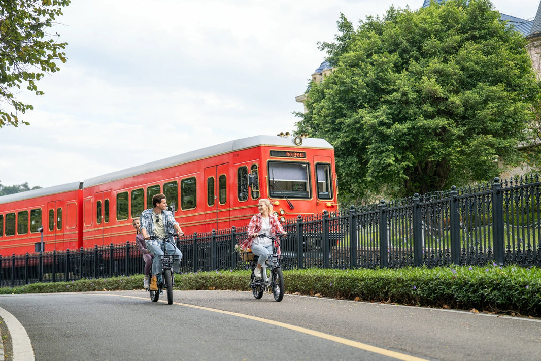 DYU C9 Langstrecken E-Bike fährt neben einem roten Zug
